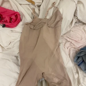 Beige body med smala axelband - En body perfekt nu till vintern ifall du vill hålla dig extra varm under kläderna eller ifall du vill få en mer snatch look!! Hel oanvänd kom tyvärr inte till användning köp direkt för 300 eller kom med bud så kan vi diskutera vill få en snabb affär då jag rensar garderoben!