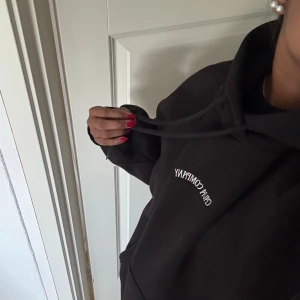 Svart hoodie från The Cava Company - Svart hoodie från The Cava Company med vit broderad text på bröstet. Klassisk modell med huva och snörning, samt rymlig passform. Perfekt för chill dagar och enkel att matcha med jeans eller mjukisbyxor och det passar bra nu till hösten och vintern!! 