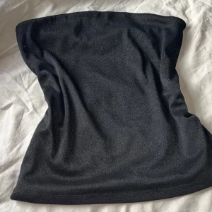  Glittrig topp från Stockh lm Studio - Svart tub topp med glitter från Stockh lm Studio i stilren design.  Perfekt som nyårstopp  eller andra festliga tillfällen. Använd en gång så inprincip ny🥰 På sista bilden ser man att de finns gummi upp till så att den sitter på plast på huden🥰