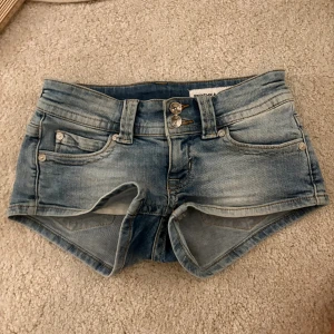 Blå denimshorts från Bershka - Säljer ett par blåa lågmidjade jeansshorts som passar perfekt till allt💕 Midjemått 35 cm