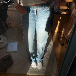 Ljusblå raka jeans från Gina tricot - Ljusblå jeans med klassisk rak passform. Jeansen har fem fickor, knappgylf och slitna, fransiga benslut för en avslappnad vibe. Perfekta för dig som gillar vintagekänsla och tidlös stil.