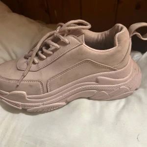 Chunky ljusrosa sneakers med platåsula - Chunky sneakers i ljusrosa med platåsula och snörning. Skorna har en rund tå och är tillverkade i syntetmaterial med mockaliknande finish. Snygg och trendig modell som ger extra höjd och passar perfekt till streetwear-looken.