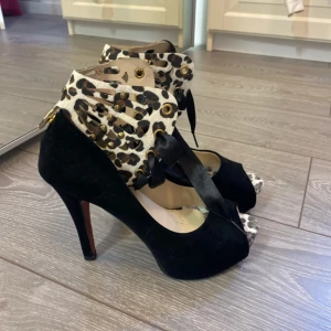 Klackskor  - Snygga klackskor med röda sulor. Leopardfärgad vid vristen går att ta bort. Den har en knapp.  