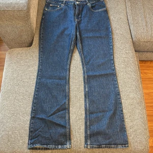 Blå bootcut jeans från Perfect Jeans - Snygga blå jeans från Perfect Jeans i klassisk bootcut-modell. Jeansen har fem fickor, gylf med dragkedja och knapp, samt kontrastsömmar. Materialet är slitstarkt denim i bomull och passformen är normal med lite utsvängda ben.