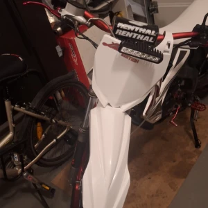 Crossplatta för Linus - Bilden visar en motorcykel eller crosscykel med Renthal styre och LED-ljus, men ingen elektronikprodukt från den angivna taxonomin kan identifieras.