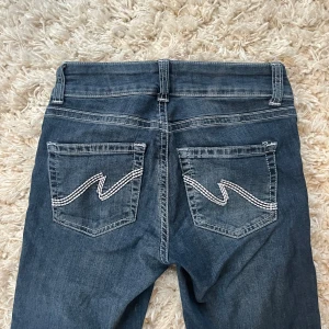 Blå bootcut jeans med broderade fickor - Snygga blå jeans med bootcut passform och låg midja. Säljer för att de inte kommer till användning, annars fina och nästan som nya❤️