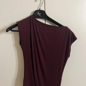 Vinröd topp - Säljer en fin vinröd asymmetrisk topp❤️