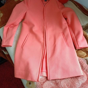 Korallrosa kappa från H&M, strl 36 - Snygg korallrosa kappa från H&M i storlek 36. Jackan har en stilren rak passform, diskreta fickor i sidorna och är helfodrad. Materialet är strukturerat och känns lätt men ändå stadigt. Perfekt för dig som vill sticka ut med färg i vår eller höst.