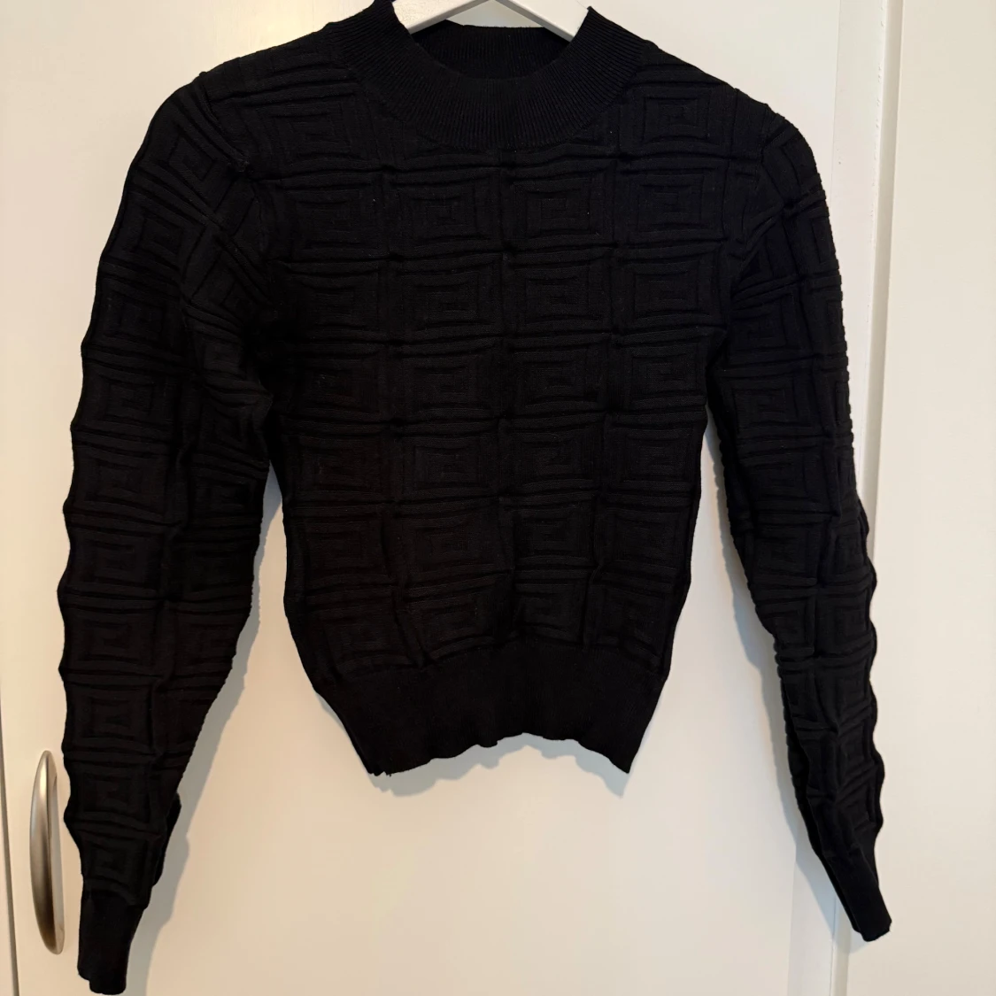Svart stickad tröja med strukturmönster