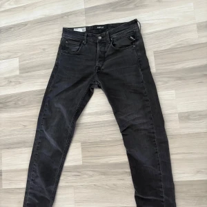 Replay Grover svarta jeans, stl 29 - Säljer ett par svarta Replay Grover jeans i klassisk femficksmodell. Jeansen har en snygg , raka ben och normal passform. Märkespatch bak i midjan och diskreta detaljer på bakfickan. Perfekta för dig som gillar stilrena svarta jeans. Ny pris 1500