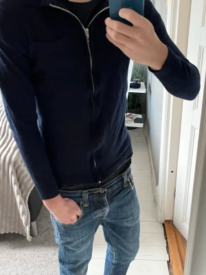 Merino ull kofta från Lindbergh White - Säljer en stilren mörkblå kofta från Lindbergh White i mjuk merinoull. Koftan har lång ärm, silverfärgad dragkedja framtill och diskret bröstficka. Passar perfekt till jeans och har en clean look som funkar året runt. Hör av er vid funderingar😁