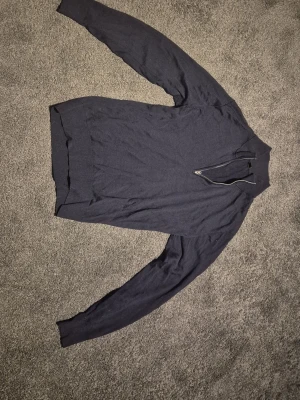 Mörkblå Stickad Halfzip - Uniqlo - Snygg mörkblå stickad halfzip. Tröjan har ribbade muddar vid ärmslut och nederkant, samt en klassisk krage. 