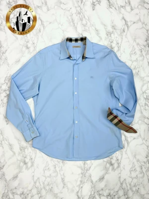 Burberry Skjorta L - Svart Burberry skjorta i storlek L i mycket bra skick. Skjortan har dessvärre ett vitt märke på vänster sida vilket dock inte är märkbart vid användning. Förutsätter att detta orsakats av deoderant. Därav priset. Skjortan är självklart äkta. Är du osäker på äkthet hänvisar jag gärna till bra källor/guider. Tveka inte på att höra av dig för fler frågor eller vid minsta fundering! Skick: 9/10