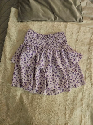 Supergullig ljuslila blommig kjol Gina Tricot XS - Jag säljer en supersöt kort sommarkjol från Gina Tricot i storlek XS. Kjolen är ljuslila med små lila blommor, har smockad midja och volangdetaljer som ger en skön och flowy känsla. Den är en perfekt volangkjol till sommaren, att matcha till söta toppar. Nypris runt 300 kr. I mycket bra skick, aldrig använd och därför priset. 💓
