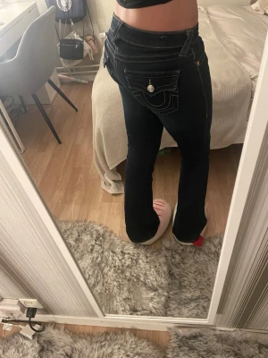 Mörkblåa True Religion Jeans - Säljer ett par jättesnygga och populära bootcut jeans från True Religion. Dessa byxor var originellt mid rise men jag har lämnat in de till en otroligt bra skräddare som har gjort de low rise. Så de är alltså som low rise modellen. Använd fåtal gånger! 💞