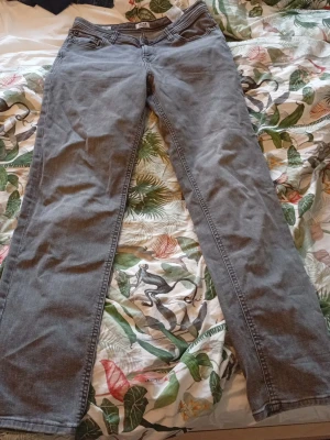 Jeans från Jack & Jones - Säljer ett par grå jeans från Jack & Jones i storlek 164. Klassisk femficksmodell med dragkedja och knapp framtill. Jeansen har rak passform och är tillverkade i jeansmaterial med snygga sömmar. Perfekt för dig som gillar enkel och stilren look. Pris kan sänkas vid en villig affär 