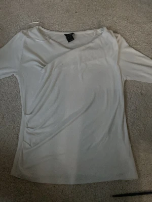 Vit långärmad topp från Lindex XS - Säljer en stilren vit kortärmad topp med volanger från Lindex i storlek XS.