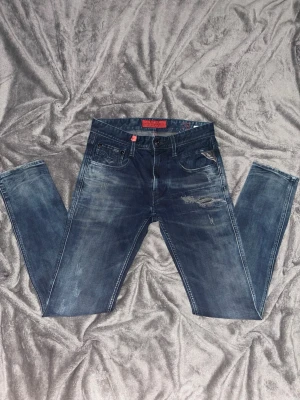 Replay Anbass jeans, marinblå 28/32 - Snygga Replay Anbass jeans, marinblåa slim fitt jeans. Storlek: 28/32. Har snygga revor vid framsidan och baksidan. Köpte den nya för 1 400 kr. 