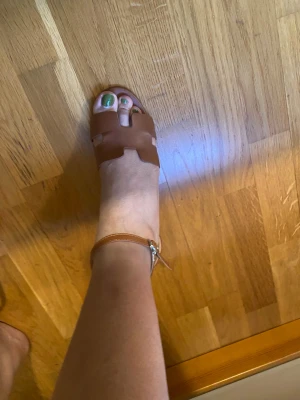 Bruna sandaler med klack och öppen tå - Säljer ett par snygga bruna sandaler med breda remmar i skinn och öppen tå. Sandalerna har en stabil klack och ett smalt ankelband med spänne. Perfekt för dig som gillar stilrena och trendiga skor med lite höjd.