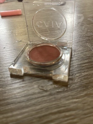 Brun rouge från CAIA - Säljer en snygg rouge från CAIA i en varm brun nyans. Kommer i en rund dosa med transparent lock och stilren design. Perfekt för att ge kinderna en naturlig färg och glow. Pudret är lätt att applicera och passar till många olika looks.