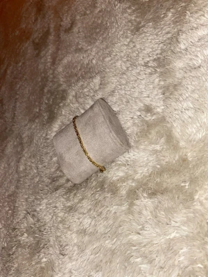 Guldfärgat kedjearmband - Snyggt guldfärgat armband med ett flätat kedjemönster som ger en cool och stilren vibe. Perfekt att bära till både jeans och skjorta för att lyfta din outfit. Lätt att ta på och av tack vare smidig låsning.