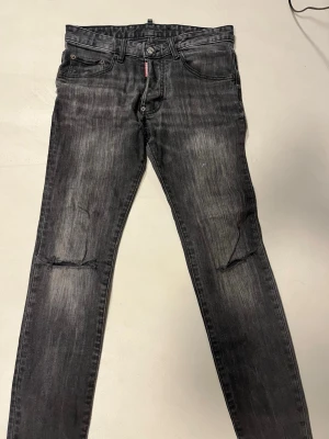 Svarta skinny jeans från Dsquared2 - Snygga svarta jeans från Dsquared2 med slitningar vid knäna och en cool tvättad look. Skinny fit och klassisk femficksdesign. Jeansens material är bomull och de har en tydlig Dsquared2-lapp bak i midjan. Perfekt för dig som gillar streetstyle och vill sticka ut. Köpta på zalando för 3k