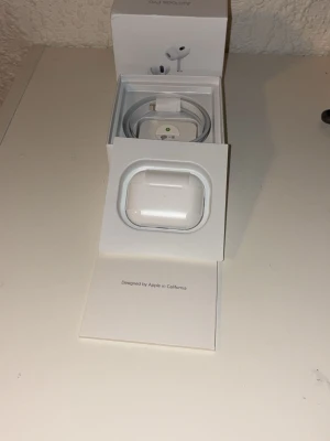 AirPods 2 pro - Säljer ett par AirPods Pro i mycket fint skick, komplett med originalförpackning och laddkabel. Hörlurarna fungerar utmärkt och batteristatus visas på bilderna. Inga synliga repor eller skador. Perfekt för dig som vill ha trådlösa hörlurar med aktiv brusreducering.