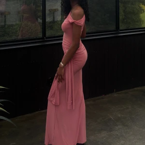 Rosa omlott långklänning oneshoulder - Säljer en snygg rosa långklänning med omlott-detalj och oneshoulder-design från prettylittlething. Klänningen är använd en gång så nyskick. Perfekt till bal, bröllop eller andra uppklädda evenemang!