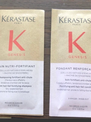 Kérastase Genesis hårvårdsprover - Två små förpackningar från Kérastase Genesis-serien, en schampo och en balsam, båda med edelweiss och ingefärsrot. Beige och vit design med röd logga. Perfekt för att testa stärkande hårvård mot håravfall.