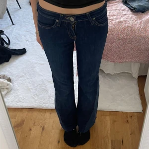 Mörkblå bootcut jeans från Lee - Lee-jeans som jag har sytt ut till bootcut, de är använda några få gånger. Det finns ett litet hål (se sista bilden) men det går enkelt att fixa. Jeansen är i storlek W25. För mått skriv! Jag köpte jeansen secondhand men jag kan inte garantera att de är äkta Lee. Små defekter förekommer men allt syns på bilderna!