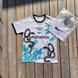 Inter Milan vit kortärmad fotbollströja - Snygg Inter Milan fotbollströja från Nike i vitt med svarta och turkosa detaljer. Tröjan har korta ärmar, svart krage och coolt ormmönster med blå blad. Digitalbits-logga på bröstet och klubbmärke i turkos. Perfekt för dig som gillar unik design.