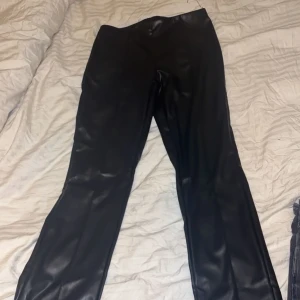 Svarta skinnbyxor från H&M XS - Säljer ett par lågmidjade skinnbyxor, dom är använda 1-2gånger och är i storlek Xs från hm och har dragkedja nere vid benet som man kan stänga eller ha öppen❤️