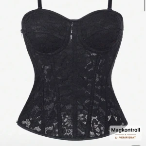 Svart spetskorsett med snörning - Säljer en svart korsett med blommig spets, justerbara axelband och snygg snörning bak. Korsetten har formade kupor och dragkedja i sidan för enkel påklädning. Perfekt för dig som vill ha en statement piece med cool siluett och detaljer. Ordinarie pris 189kr. Aldrig använd 