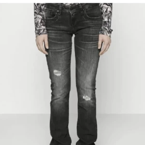 Valerie jeans LTB - Snygga svarta jeans med bootcut passform och slitna detaljer på låren. Jeansen har klassisk femficksdesign och är tillverkade i ett robust denimtyg. Perfekta för dig som gillar en cool och avslappnad stil.