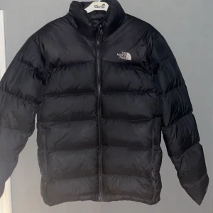 Svart pufferjacka från The North Face - Säljer en svart pufferjacka från The North Face, Perfekt för kalla dagar och riktigt skön att bära. Använd fåtal gånger och är i mycket fint skick, nypris 2799 från The north face hemsida.