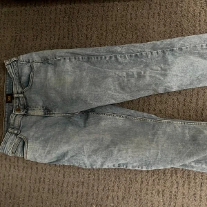 Ljusblå skinny jeans från Lee - Säljer ett par ljusblå jeans från Lee med klassisk femficksdesign och skinny passform. Jeansen har normal midja och är gjorda i mjukt denimtyg. Perfekta för dig som gillar en smal siluett och enkel stil.modellen är 180 och väger 65