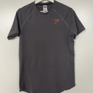 Mörkgrå Gymshark t-shirt  - Mörkgrå T-shirt från Gymshark. Oanvänd och har kvar sin förpackning. Strl S. 