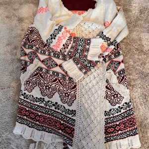 Stickad mönstrad klänning Odd Molly - Superfin stickad kofta från Odd Molly med unikt mönster i vinrött, svart, rosa och beige. Koftan har långa ärmar, v-ringning och snygga virkade detaljer. Perfekt för dig som gillar boho-vibe och vill sticka ut med coola mönster och färger.