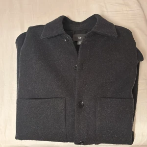 Grå overshirt från H&M - Stilren svart overshirt från H&M i relaxed fit. Perfekt nu när det börjar bli lite kallt. Nästan nytt skick. Pris kan diskuteras!! Passar dig runt 180.