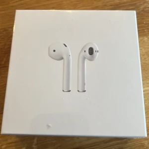 Apple AirPods med Wireless Charging Case - Helt nya Apple AirPods med trådlöst laddningsetui, modell A2032/A2031/A1938. Kompatibla med iOS, Apple Watch och Mac. Originalförpackning, obruten plast och inga synliga skador. Perfekt för trådlös musik och samtal med hög kvalitet.