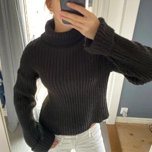 Svart ribbad polotröja stickad - Svart stickad polotröja med ribbad struktur och lång ärm. 