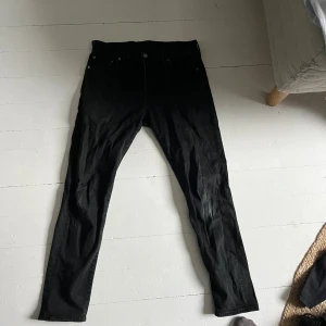 Svarta jeans från Levi's - Svarta jeans från Levi's med klassisk femficksdesign och slim passform. Materialet är jeans med en mjuk stretchkänsla för extra komfort. Perfekt för dig som gillar en clean och stilren look.