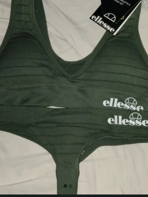 Grön sport set från Ellesse - Säljer en grön sportig set från Ellesse med vit logga på bröstet. Är tillverkad i ett stretchigt material med diskreta ränder. Perfekt för träning eller chill dagar.