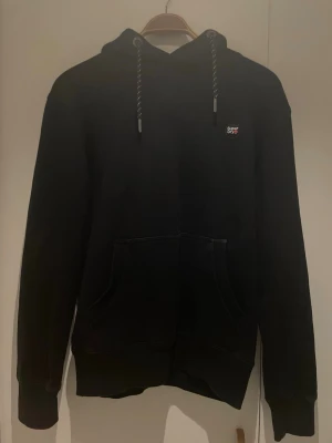 Superdry hoodie - En schysstare superdry hoodie som är riktigt bekväm och är gjord av kvalite. Sista bilden hur jag mäter, 61cm lång.