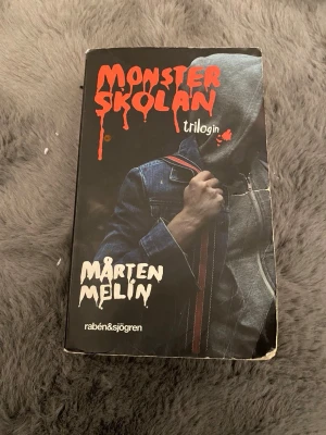 Monsterskolan trilogin - En samlingsvolym med Monsterskolan-trilogin av Mårten Melin. Perfekt för dig som gillar spänning, mystik och monster i skolmiljö! Omslaget har en cool, mörk design som lockar till läsning för ungdomar och unga vuxna.