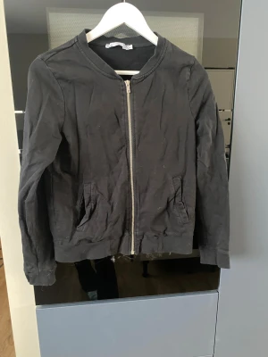 Svart kofta - Svart kofta från 157 i storlek L. Koftan har klassisk rundad krage, dragkedja framtill och två fickor på sidorna. Enkel och clean design som passar till det mesta.