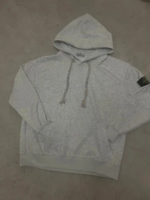 Stone Island Hoodie - Grå - Säljer en Stone Island hoodie i ljusgrå. Klassisk och clean design med ikoniska Stone Island-badgen på armen.  ✅ Mycket fint skick ✅ 100 % original ✅ Hög kvalitet & premium material ✅ Tidlös streetwear – alltid efterfrågad  Perfekt för både vardag och streetstyle.  📩 Hör av dig vid minsta lilla – kan skicka fler bilder och detaljer.