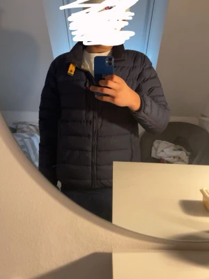 Parajumper jacka  - Säljer en mörkblå lättvikts dunjacka från  Parajumper  i storlek M. Jackan har quiltad design, dragkedja framtill och en gul detalj vid kragen. Perfekt för vår  dagar och riktigt skön att bära. Har ett litet håll vid dragkedjan 