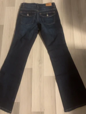 Mörkblå bootcut jeans - Säljer ett par mörkblå jeans med bootcut passform och snygga kontrastsömmar, oanvända