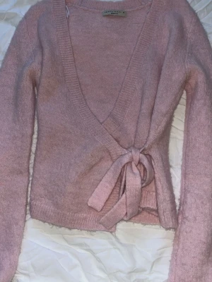 Rosa omlottkofta från Gina Tricot - Rosa stickad tröja ifrån Gina tricot i storlek Xs💞super fin säljer för den kommer inte till användning💞skickar så snabbt jag kan! Den är använd ca 4-5 gånger och har inga defekter alls